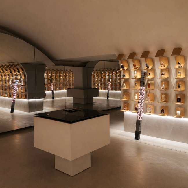 Mur d'exposition de flacons de parfum sur alcôves bois rétroéclairées, conception lumière par Ponctuelle pour L’Oréal Paris