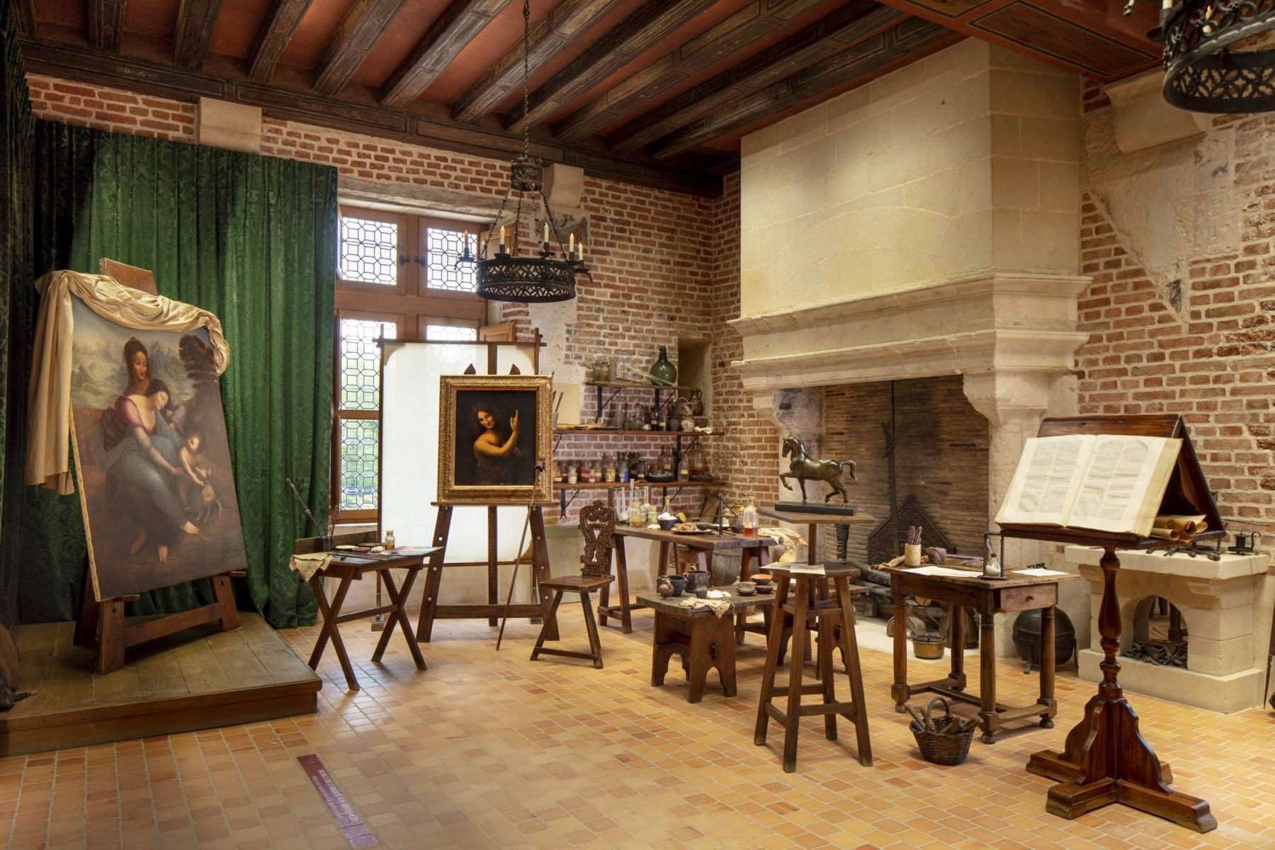 Vue large de l'atelier de peinture de Léonard de Vinci au Château du Clos Lucé avec cheminée monumentale, conception lumière Ponctuelle