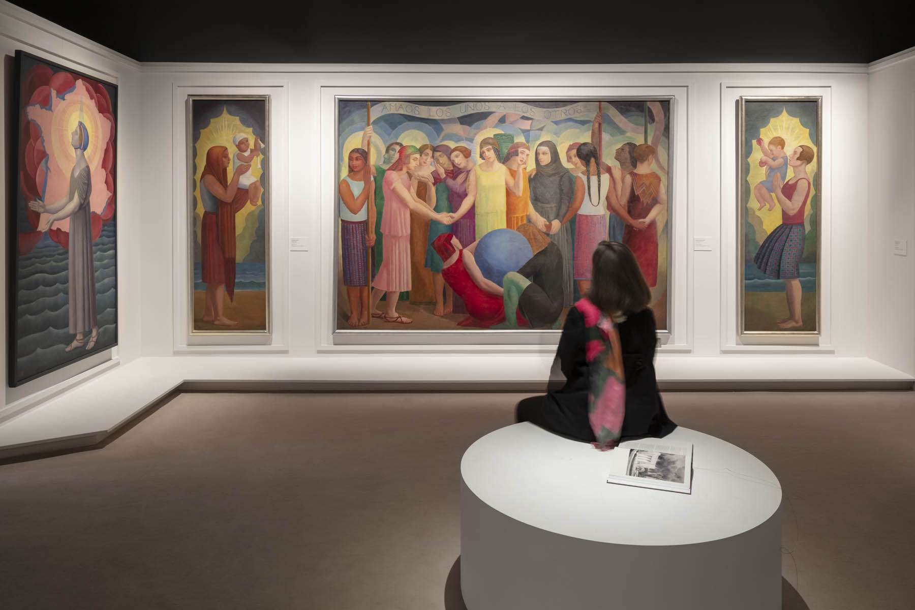 Salle d'exposition Art Déco France avec toiles figuratives éclairées et visiteuse assise, conception lumière Ponctuelle