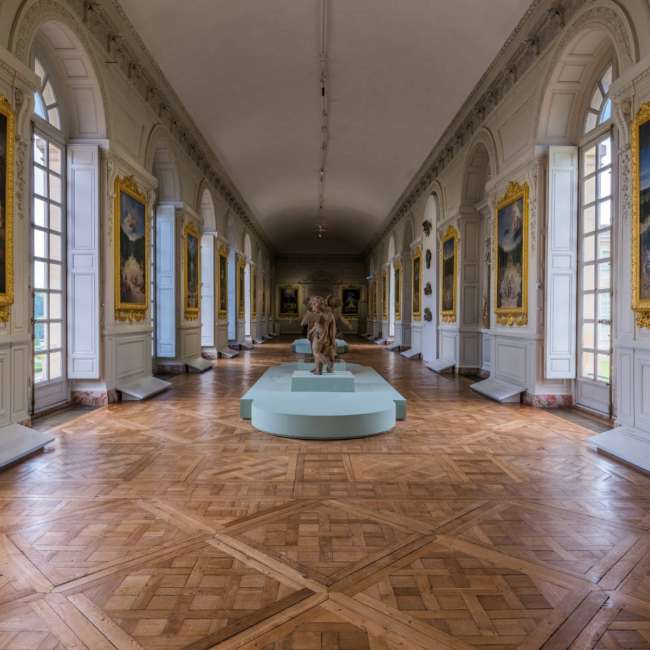 Sculptures de putti en terre cuite exposées devant des tableaux de jardins, Galerie des Cotelles, Château de Versailles, conception lumière Ponctuelle