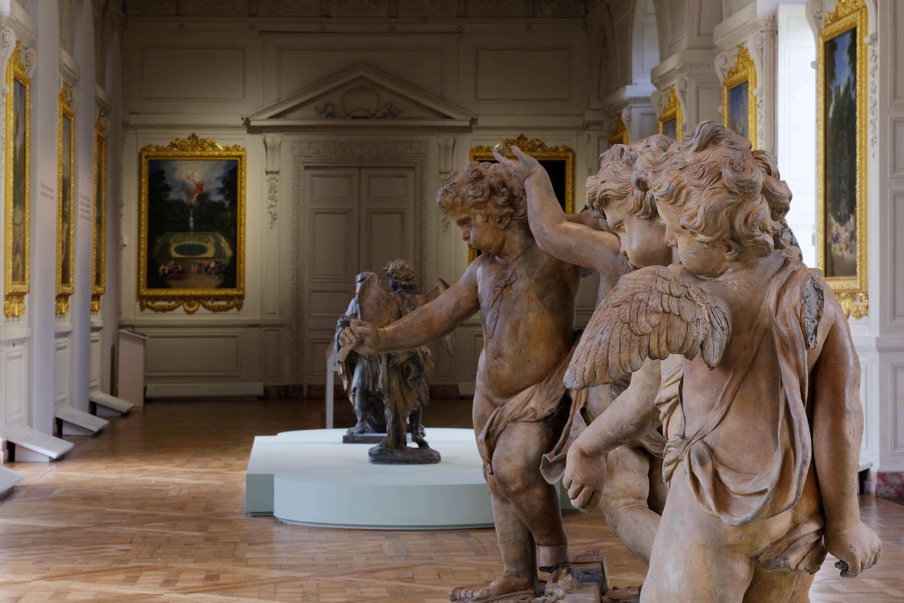 Groupe de sculptures de putti en terre cuite exposées dans la Galerie des Cotelles au Château de Versailles, conception lumière Ponctuelle