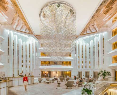 Hall de réception du JW Marriott Cannes avec suspension lumineuse monumentale et atrium sur plusieurs niveaux, conception lumière Ponctuelle