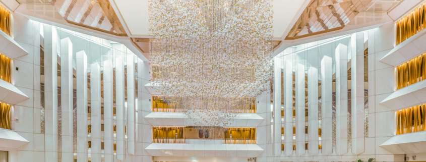 Hall de réception du JW Marriott Cannes avec suspension lumineuse monumentale et atrium sur plusieurs niveaux, conception lumière Ponctuelle