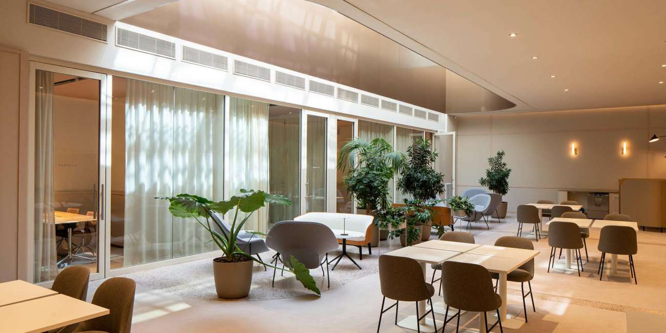 Espace de restauration avec verrière courbe et végétation, mise en lumière Ponctuelle